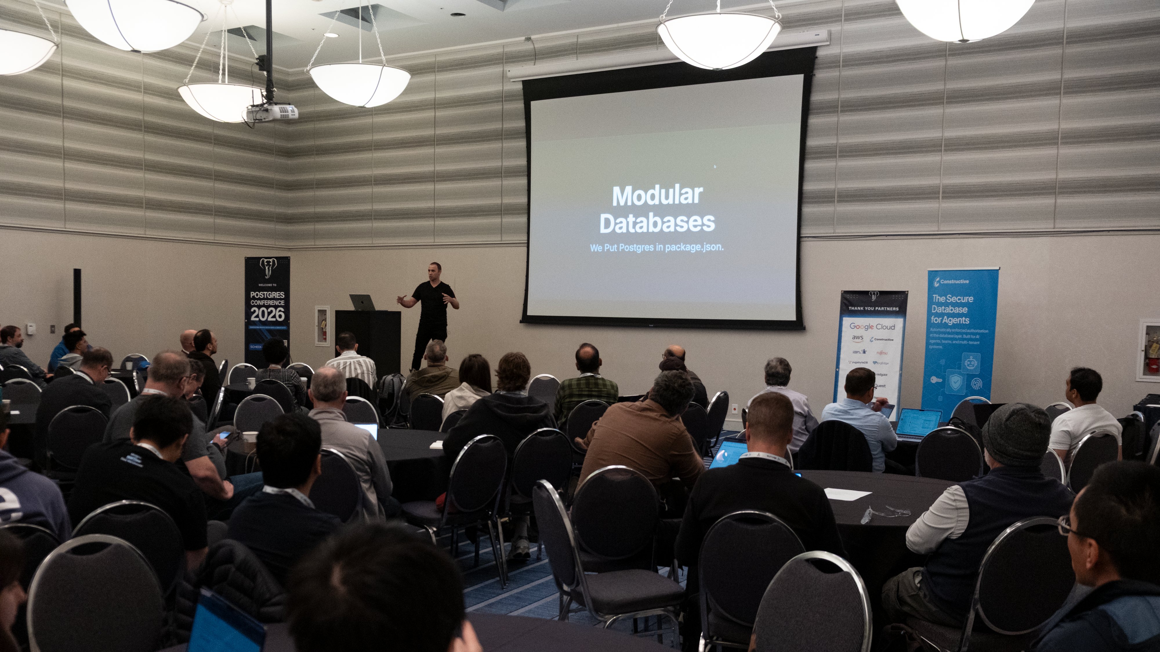 Dan Lynch on stage at PostgresConf 2026